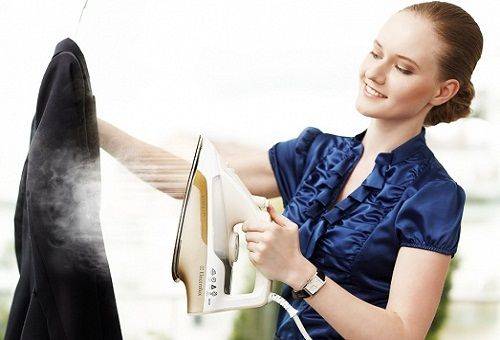 fille nettoie un manteau avec un fer à repasser