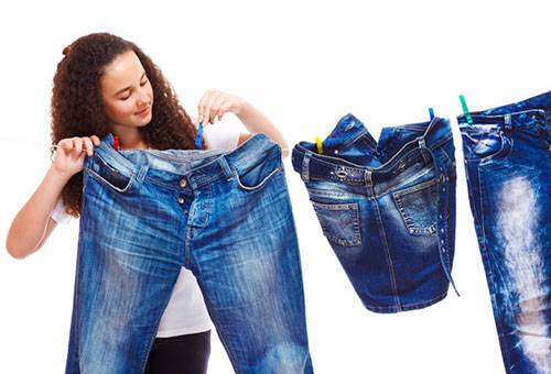 Fille suspend des jeans pour le séchage.
