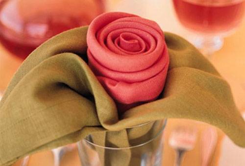 Serviettes pliées avec une rose dans un verre