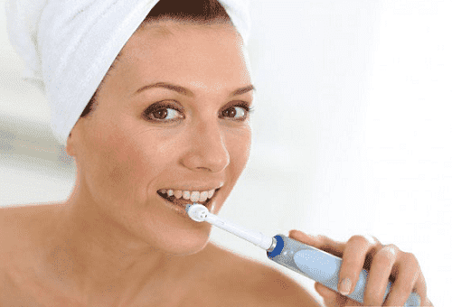 fille avec brosse à dents électrique