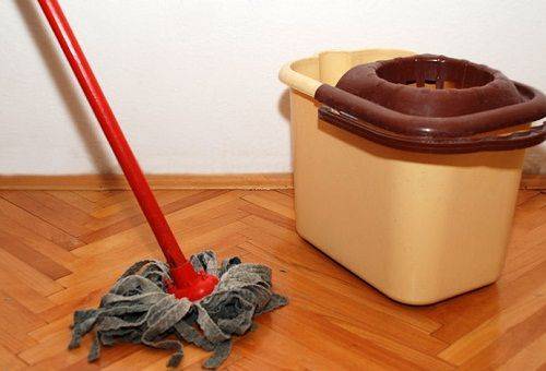 fille nettoie le sol avec un chiffon