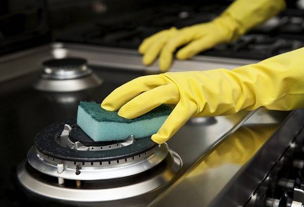 femme nettoie la cuisinière