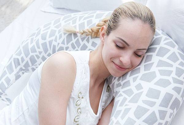 La fille est allongée sur un oreiller pour se nourrir