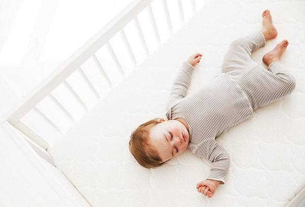 Enfant en bas âge dormant dans un berceau