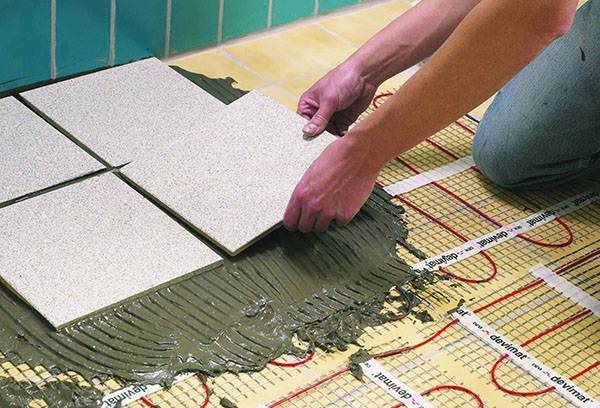 Poser des carreaux sur le sol chaud