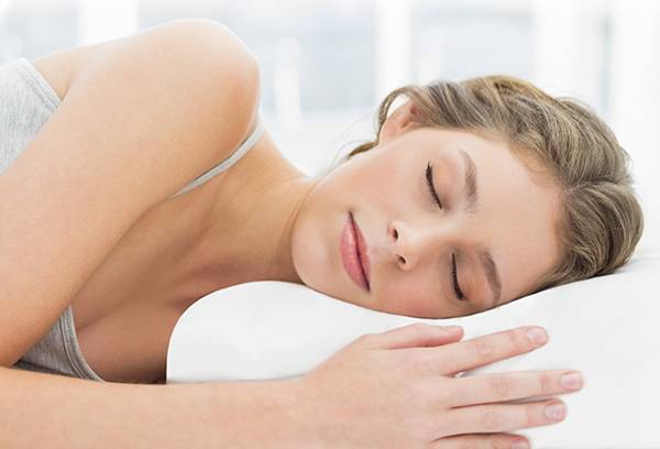 Fille dormant sur un oreiller orthopédique