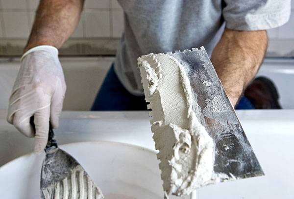 Application de colle de plâtre sur la truelle crantée