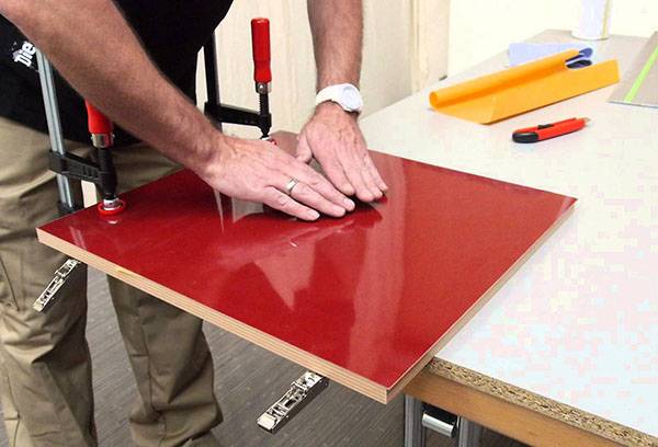 Application d'un film de PVC sur une plaque de fibres