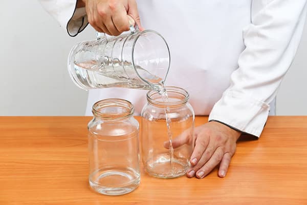 Un homme verse de l'eau dans des canettes