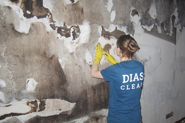 Un employé de nettoyage fait le nettoyage après un incendie