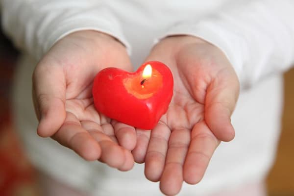 Bougie allumée dans les mains