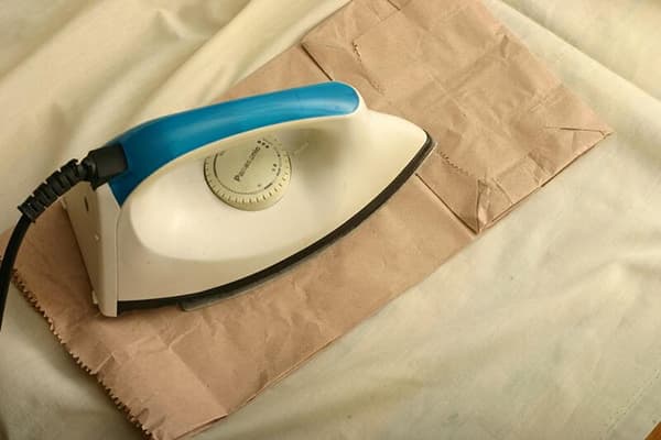 Repassage de tissu à travers du papier