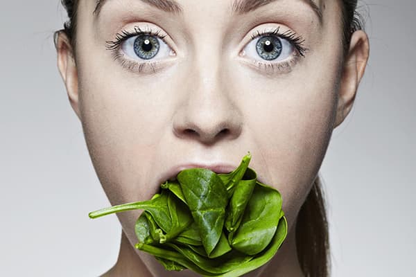 Fille aux épinards dans la bouche.
