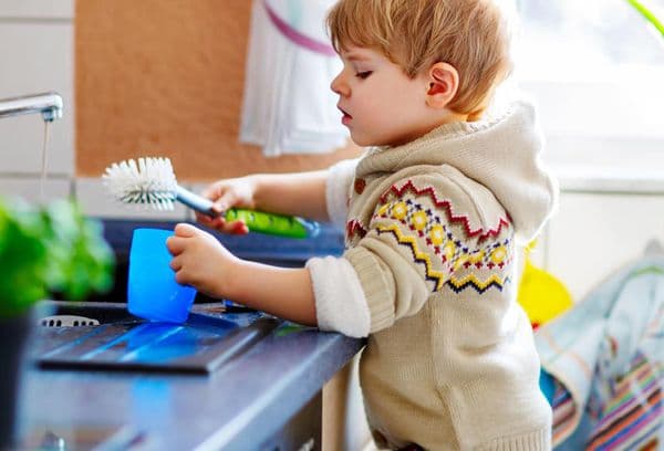 petit garçon fait la vaisselle