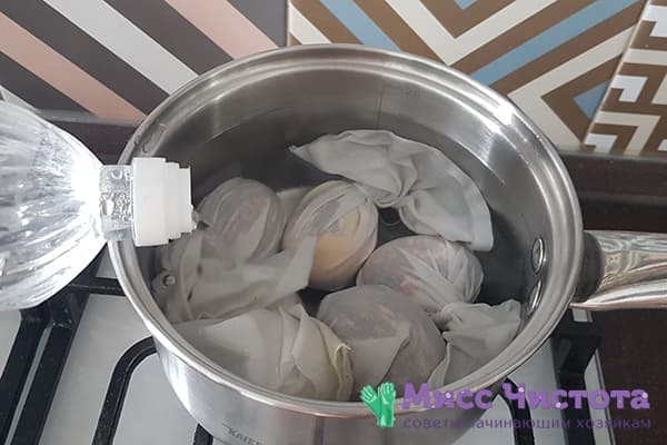 Oeufs dans des sacs en tissu dans une casserole avec de l'eau