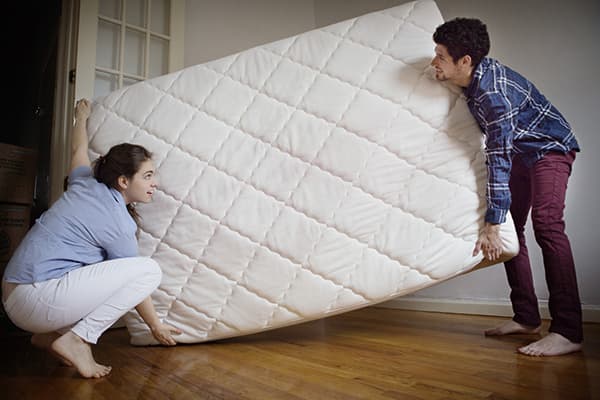Couple porte un nouveau matelas