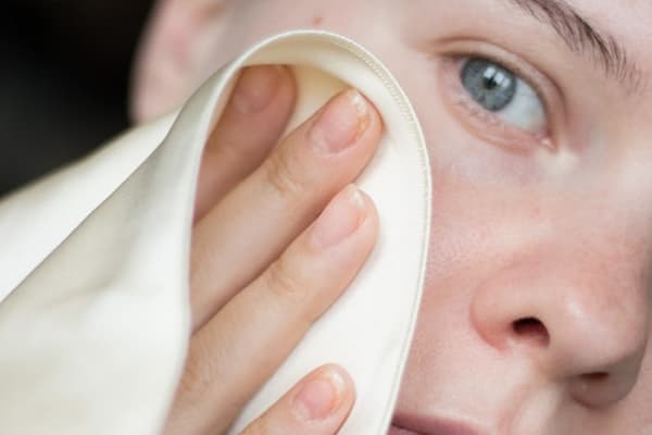 Fille essuie son visage avec une serviette