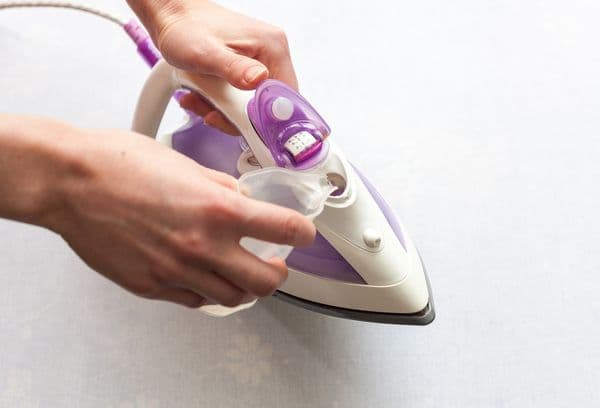 Verser de l'eau dans le réservoir de fer