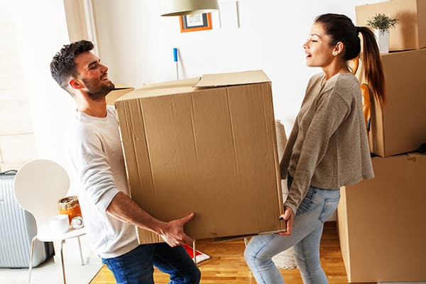 Un homme et une femme portent une grande boîte