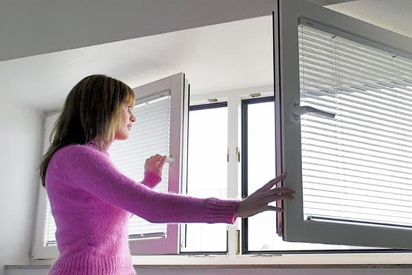 Fille ouvre une fenêtre pour aérer