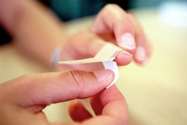 La jeune fille scelle un doigt avec un pansement