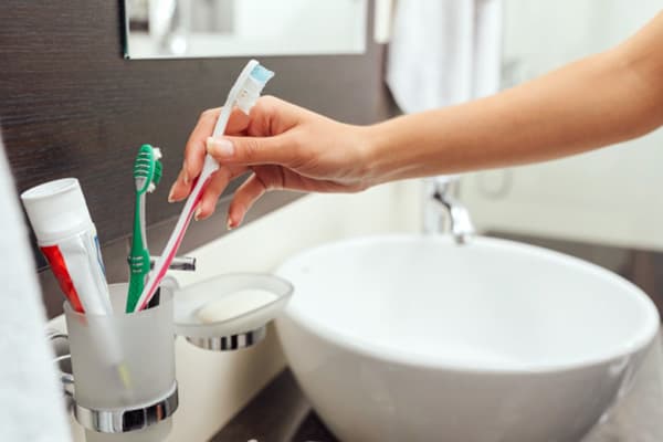 En utilisant une brosse à dents