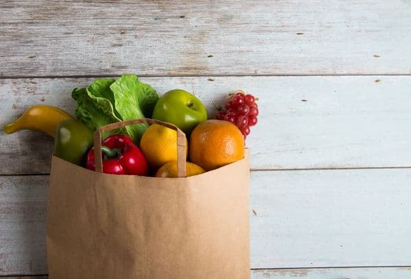 Sac en papier avec des fruits et des légumes.