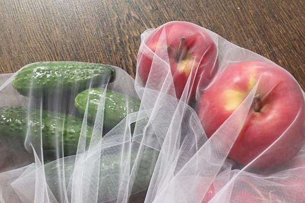 Concombres et pommes dans des sacs écologiques